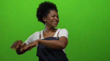 Yeşil ekran arka planında önlükle gülümseyen kadın neşeli ifade sergiliyor profesyonelce izole edilmiş canlı sahneler kuruyor.