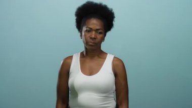 Beyazlı kadın alnına dokunuyor, parmağı mavi arka planda, izole edilmiş arka planda düşüncelerini aktarıyor..