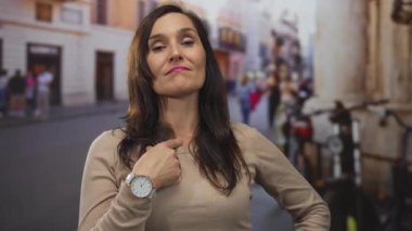 Genç İspanyol kadın yoğun bir şehir caddesinde kendini işaret ediyor; özgüven özgüveni.