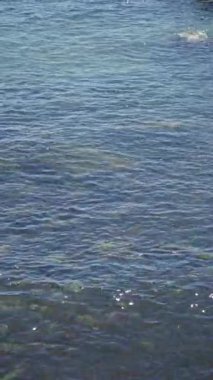 Akdeniz, güneşli bir günde güneş ışığını yansıtan hafif dalgalarla, sakin, rahatlatıcı bir atmosferi olan turkuaz su sergiliyor. Açık deniz ve yaz sahneleri için mükemmel..