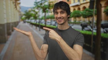 Gülümseyen ve parmakla işaret eden adam kalabalık caddede bulanık arabalar ve ağaçlarla avuç içini açıyor; davet.