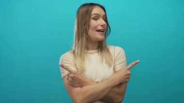 Kadın, kararsızlık ve neşe saçan canlı yeşil bir zemin üzerinde her iki tarafı da mutlu bir şekilde işaret eder..