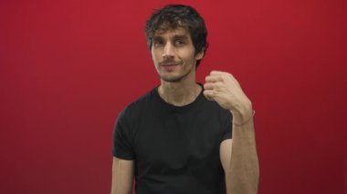 Eli ve ön kolu açık bir adam stüdyoda kameraya dönüp nazikçe gülümsüyor..