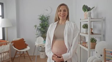 Bebek odasında hamile karnı büyüyen bir kadın, beklenti neşe.