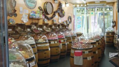 İçinde çeşitli tatlılar bulunan ahşap varillerle dolu renkli bir ev ortamında şekerci dükkanı..