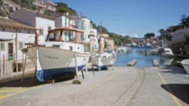 Kala figür limanı, Mallorca 'da bulanık tekneler, temiz mavi gökyüzünün altında, dağılmış Akdeniz köyü arka planı.