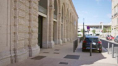 Marsilya, Fransa 'daki bulanık açık hava sokak sahnesi. Arka planda dağılmış arabalar ve tarihi mimari açık Avrupa gökyüzü altında bir bokeh etkisi gösteriyor..