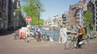 Bulanık bisikletçiler ve yayalar, Amsterdam Kanalları boyunca, Hollanda kentsel hayatının özünü kaydediyorlar. Bisikletlerle klasik kanal kenarı mimarisine karşı yumuşak odaklı..