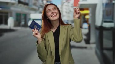 Şehir caddesinde elinde Kore pasaportu tutan kadın gülümsüyor ve yukarı doğru işaret ediyor, seyahat ve keşif sergiliyor..