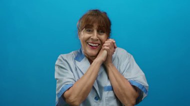 Mavi arka planda gülümseyen İspanyol üniformalı son sınıf öğrencisi kadın, temizlik işinde mutluluk ve memnuniyetini ifade ediyor, profesyonel bir portre için izole edilmiş..