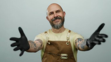 Eldivenli ve önlüklü sakallı adam izole edilmiş beyaz bir arka plana karşı hoş geldin sarılması teklif ediyor..