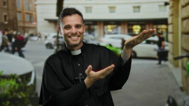 Sokak jestleri yapan rahip kılığındaki genç adam gülümserken ve arabalarla ve binalarla çevriliyken şehir manzarası ve dini bir tema izlenimi veriyor..