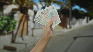 Czech Koruna banknotları elinde tutan adam açık şehir sokaklarında para ve ekonomi teması sergiliyor..