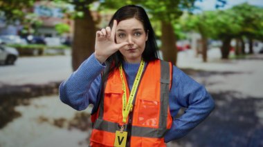 Turuncu yelekli kadın sokak gösterisinde ezik jestler yapıyor esmer saçlı ve şehirli gönüllü iş yapıyor..