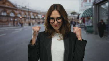 Şehir caddesinde kendine güvenen bir kadın coşkusunu ve mutluluğunu canlı bir şehir ortamında sergiliyor..