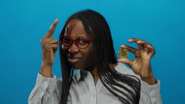 Bitcoin 'i elinde tutan kadının mavi arka plana karşı kendine güveni tam, modern finans ve kripto para eğilimleri sergiliyor..