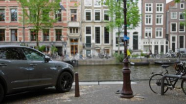 Amsterdam Kanalı 'nın bulanık manzarası. Hollanda' daki pikoresk su yolunu kaplayan çözünmüş araba ve bisikletler..