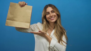 Bir kadın bir eliyle kese kağıdını tutuyor ve diğer eliyle bir stüdyoda sunuyor; ürün tanıtım pazarlama cazibesi.