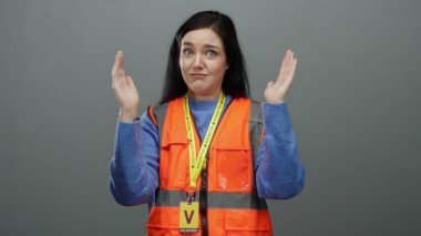 Gri arka planda elleri olan turuncu yelekli kadın toplum hizmeti ortamlarında gönüllülük ve iletişim tasvir ediyor.