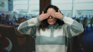 Lokantada elleri örtülü gülümseyen, sonra da gözlerini şen bir sürprizle açan, gözlük takan, çizgili bir süveter giyen, neşe saçan bir kadın..