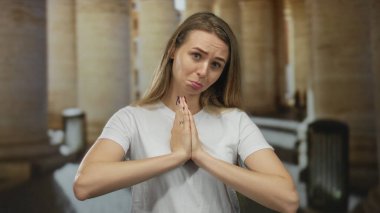 Tarihi eski şehir sokağında sütunları ve hafif ışıklarıyla umut dolu bir yüzle dua eden kadın..