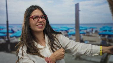 Açık gökyüzünün altındaki bir sahil caddesinde çıplak elleriyle halat çeken genç bir kadın. Kararlılık..