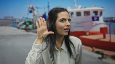 Limandaki İspanyol kadın açık havada düşünceli bir ifadeyle bir teknede jest yapıyor..