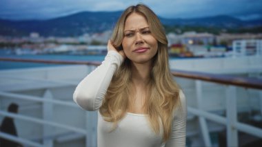 Limana tepeden bakan güvertede el ele tutuşan beyaz elbiseli bir kadın..