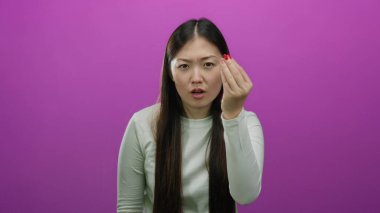 İzole edilmiş pembe arka planda, el hareketleriyle hayal kırıklığını ifade eden, uzun düz saçları olan ve günlük beyaz gömlek giyen bir kadın..