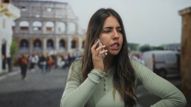 Roma 'da gündüz vakti açık havada kültür mirası ve seyahat ruhunu yakalarken Roma Kolezyumu' nun önünde akıllı telefondan konuşan bir kadın duygularını dile getiriyor..