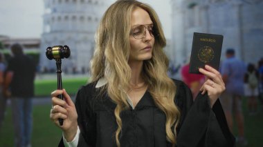 Meksika pasaportu ve tokmağı elinde tutan kadın yargıç pisa kulesinin önünde yasal otoriteyi somutlaştırıyor ve İtalya 'da uluslararası seyahat ediyor..