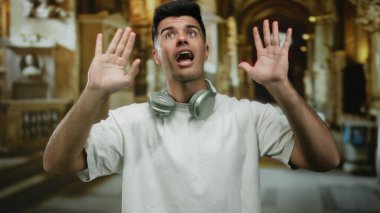 Müzenin içinde kulaklık takan yakışıklı, etkileyici ve karizmatik görünüşlü, tarihi mimariyle çevrili genç bir adam..