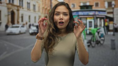 Canlı bir şehir caddesinde şaşkınlığını ifade eden bir kadın hareketli bir şehir ortamında enerji ve merakla dolu bir açık hava anını yakalıyor..