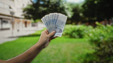 Güney Koreli adam bir açık hava parkı ortamında para ve finans konularını ön plana çıkararak mali başarı ve küresel ekonomiyi vurguluyor..