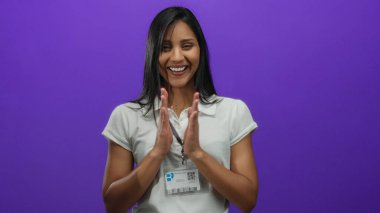 İp takan genç bir kadın, canlı mor bir arka plana karşı heyecanlı bir şekilde alkışlıyor, ıssız bir yerde şaşkınlık ve neşe taşıyor..