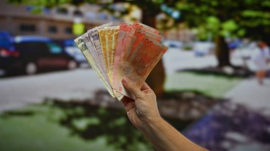 Filipinli pezoların el ele tutuşması kentsel sokak arkaplanı hareketli bir şehirde iş yatırımlarının potansiyelini gösteriyor..