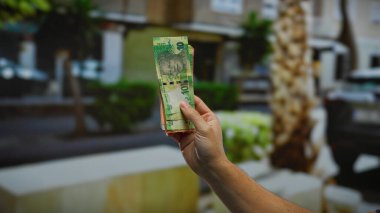 Güney Afrika Rand paralarını elinde tutan bir adam şehrin bir caddesinde açık hava finans ve ekonomisini gösteriyor..