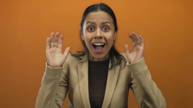 İspanyol kadının gözlerini ovuşturması neşeli bir şekilde parlak turuncu arka planda şaşkınlık ve hazzı somutlaştırıyor..