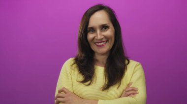 Genç İspanyol kadın parlak pembe stüdyo ortamında kollarını kavuşturarak güçlü bir duruş sergiliyor; reddediliyor..