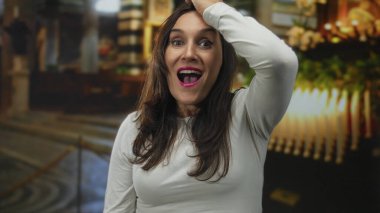 İspanyol kadın kilisenin içinde mumlar ve bulanık arka planla şaşkınlık ve ruhani bir yansıma ile şaşkınlığını ifade ediyor..