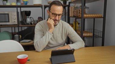 Ofisteki adam mikrodalga fırın ve mutfak gereçleriyle çevrili bir tablet kullanarak odak ve teknolojiyi kapalı bir ortamda temsil ediyor..