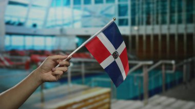 Yolcu gemisinde Dominik Cumhuriyeti bayrağını tutarken tatilde kültürel ve ulusal gururu ön plana çıkaran mavi okyanus manzaralı deniz seyahati deneyimlerini yakalıyor..