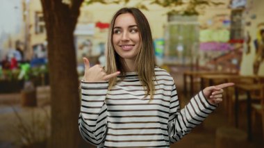 Telefon eden ve şehir sokağını işaret eden bir kadın canlı ve anlamlı bir tavırla gündelik tarzını sergiliyor..