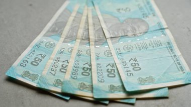 Hindistan 'dan gelen para birimini gösteren beton bir yüzeye yayılmış 50 rupilik banknotlar..