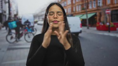 Şehir merkezinde kalabalık bir sokakta meditasyon yapan bir kadın. Gözleri kapalı, hareketli şehir hayatının ortasında huzur bulan bir kadın..