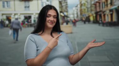 Uzun siyah saçlı, geçmişi bulanık, günlük giysiler giymiş, kendine güvenen, görünmeyen bir şey sunan genç bir kadın..