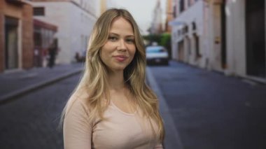 Bej rengi bluzlu sarışın kadın, kaldırım taşı caddesinde avuçlarını açık gösteriyor. Davetiyeye açık dostluğa hoş geldin..