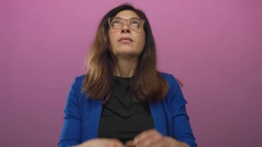 İspanyol orta yaşlı, gözlüklü, elleri ve gözlüklü bir kadın pembe stüdyoda imza atar, günlük sakin meditasyon pratiği yapar..