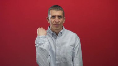 İzole edilmiş kırmızı duvarın önünde gömlek giyen beyaz bir adam. Yüzünde çeşitli ifadeler ve kapalı gözler var..