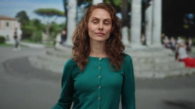 Kadın açık bir günde şehir ortamında kolunu rahatça uzatıyor. Güç ve güç katıyor ve şehir manzarasıyla donatıyor..